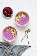 Bowl of oat granola with yogurt, fresh raspberries, cranberries