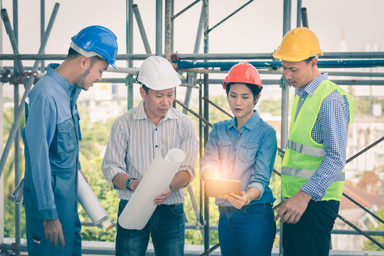 Team Of Engineer And Architects Discussing Layout Building In .tablet Computer At Worksite