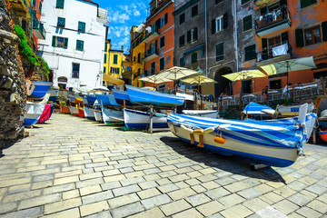 Fototapeta na wymiar Amazing street with colorful fishing boats in Riomaggioare village, Italy
