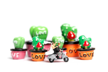 Miniature people : Couple riding the motorcycle in the garden  , Valentine's Day concept