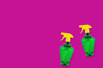 Fototapeta na wymiar Pair of plastic sprayers on pink background with copy space for your text