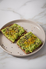 Avocado Kurkuma Sesam Vollkorn Sonnenblumenkern Brot als Snack oder Frühstück auf Marmor Hintergrund