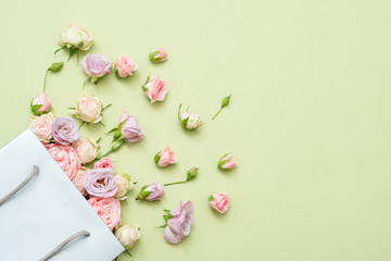 Fresh roses delivery. Flower congratulation concept. Copy space on green background.