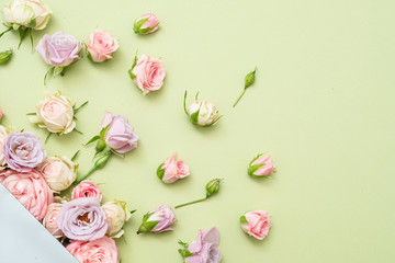 Obraz na płótnie Canvas Anniversary flower decor. Assorted fresh roses on green background. Flat lay.