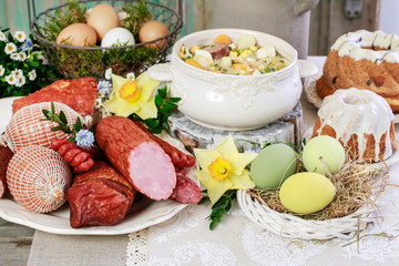 The sour rye soup, easter cakes and saussages on the table.