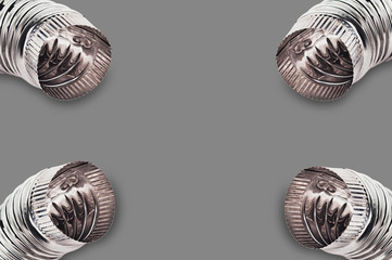 Four chrome corrugated elbows of pipes for air, water, oil or gas in corners on gray background with copy space for your text