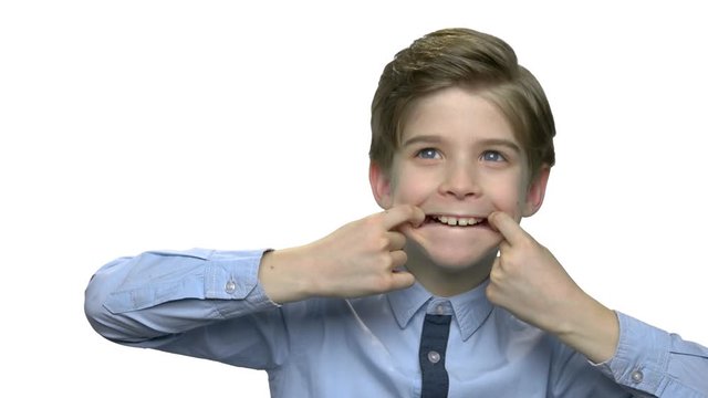 Preteen boy making funny face grimace. Little caucasian boy making monkey face. Kid fooling around.
