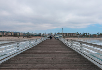 Wooden bridge to the ocean. Pacific Beach Pier or Crystal Pier.