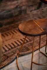Rustic wood and bronze metal bar stools. Close up details. Coffee shop, home loft interior design, minimalism concept