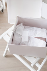 White opened box with wrapping paper and pink linen cloth. Copyspace for text
