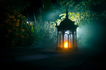 Retro style lantern at night. Beautiful colorful illuminated lamp at the balcony in the garden....
