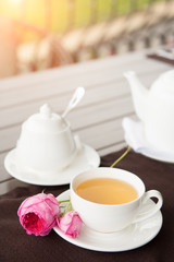 White tea Cup with teapot and sugar pot on the table