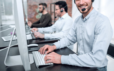 smiling call center operator works on the computer