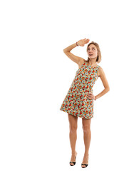 Young girl in a short dress in full growth looks up, is isolated on a white background, place for text