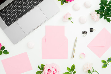 Laptop, roses flowers, diary, pen, envelope and petals on white background. Flat lay. Top view.