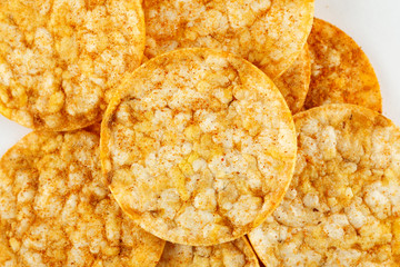Whole grain corn and rice chips with paprika on a white background
