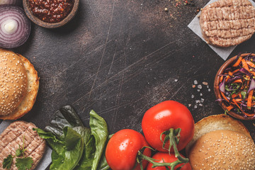 Ingredients for meat burgers on dark background, top view, copy space.