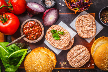 Ingredients for burgers on dark background, top view.