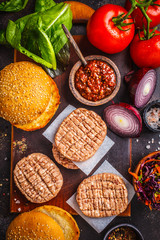 Ingredients for burgers on dark background, top view.