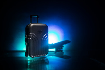 stack of traveling luggage in airport terminal and passenger plane flying over sky