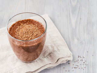 Chocolate chia pudding in glass on gray wooden table. Healthy vegan breakfast with copy space.