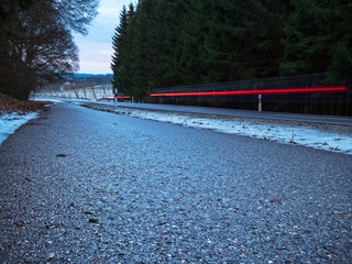 Long Exposure vehicle light along the forest road during frozen road