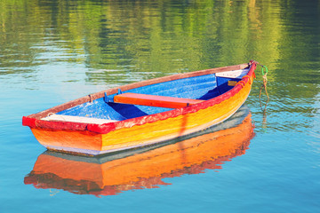 Naklejka premium Colorful rowboat floating on clear water