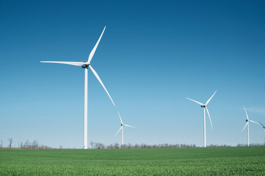 Wind Power Station On Field. Technology And Inovation. Green Energy Composition. Wind Turbines. Industrial Landscape