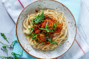 Spaghetti with tuna balls in spicy tomato sauce and rocket