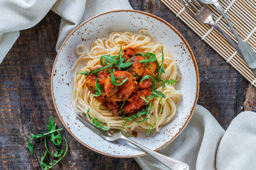 Spaghetti with tuna balls in spicy tomato sauce and rocket