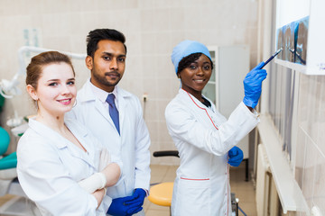 A multinational group of dentists examines x-rays in the presence of a patient. Practice at a medical university.