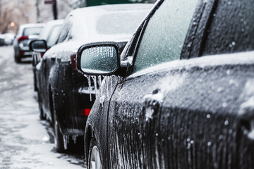 Freezing rain ice coated car. Black vehicle car covered in freezing rain, icicles hanging from side...