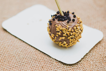 Apple covered in milk chocolate with nuts