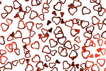 Little red confetti hearts on white background.