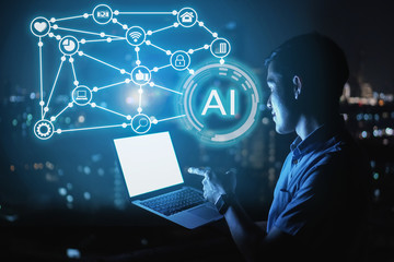 Businessman stand on roof top using laptop with hold the (AI)Artificial intelligence hologram,smart city and network connect concept