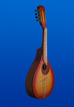 Two-tone red and yellow mandolin isolated on blue background. Vertical photo.