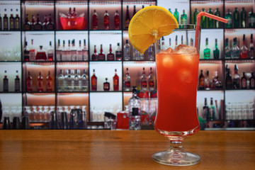 Tequila sunrise cocktail in martini glass decorated slice of orange