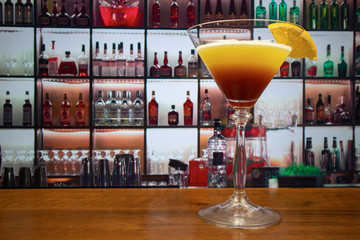 Tequila sunset cocktail in martini glass decorated slice of orange