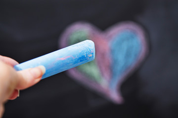 Drawing of heart with blue crayon on blackboard