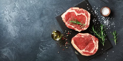 Fotobehang Fresh meat on slate black board top view. Raw beef steak and spices for cooking. © juliasudnitskaya
