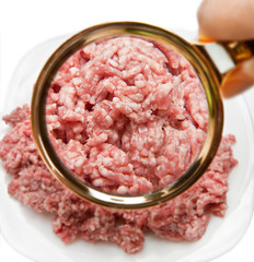 Minced red meat with a magnifying glass. We study the composition of products.