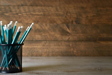 lead blue pencils in black metal holder pot on a wooden background