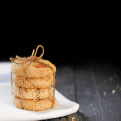 Homemade almond cookies stacked in a dark background