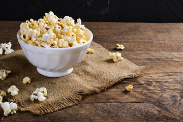 Air salty popcorn.A bowl of popcorn on a wooden table.Salt popcorn on the wooden background .  With space for text.Top view.popcorn texture.Chees .