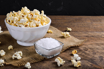 Air salty popcorn.A bowl of popcorn on a wooden table.Salt popcorn on the wooden background .  With space for text.Top view.popcorn texture.Chees .