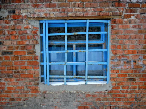 old brick wall and window with bars