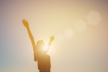 Silhouette of a girl with arms outstretched, sun, rays, evening, sunset