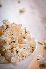 Salt popcorn on the wooden table, selective focus