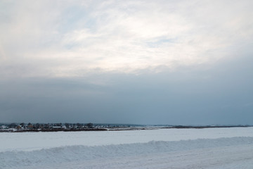Winter river landscape with blue sky and white clouds