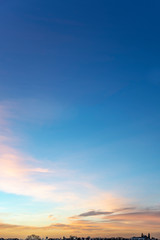 Portrait view of an early morning sky with tin and small clouds lighted by the vivid morning sunrise at the horizon